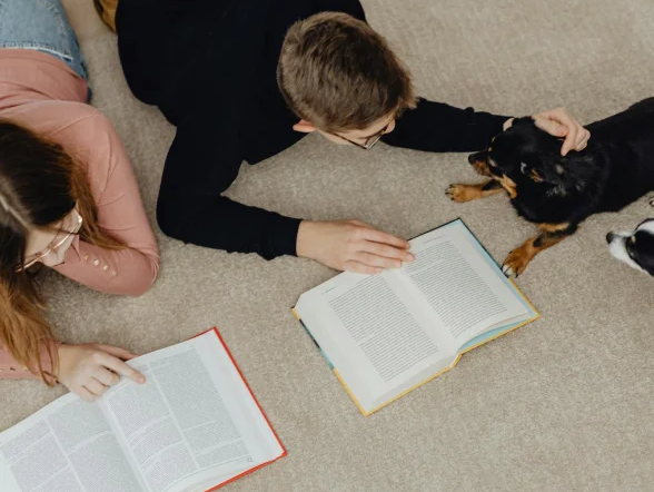 kids reading, laying down on carpet