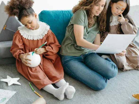 group of kids sitting, playing on carpeted floor